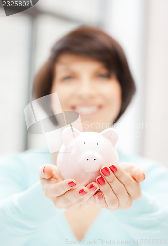 Image of lovely woman with piggy bank