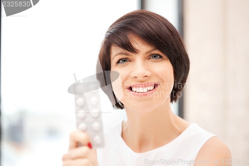 Image of young beautiful woman with pills