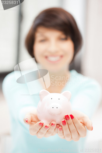 Image of lovely woman with piggy bank