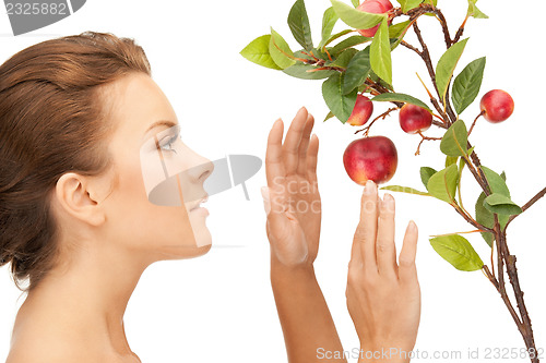 Image of lovely woman with apple twig