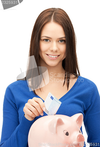 Image of lovely woman with piggy bank and money
