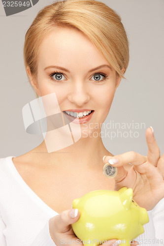 Image of lovely woman with piggy bank and money