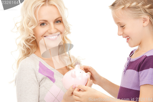 Image of mother and little girl with piggy bank