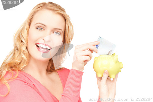 Image of lovely woman with piggy bank and money