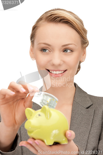 Image of lovely woman with piggy bank and money