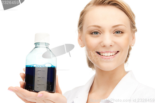 Image of lab worker holding up bottle with blue liquid