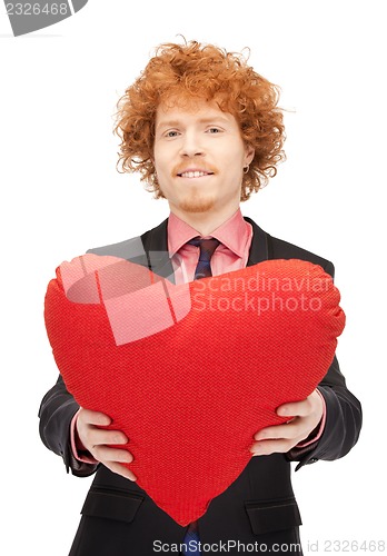 Image of handsome man with red heart-shaped pillow