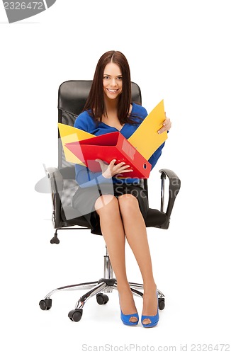 Image of young businesswoman with folders sitting in chair