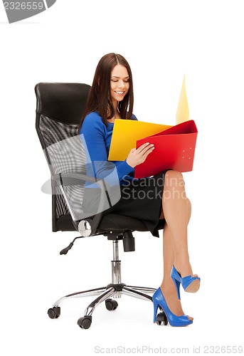 Image of young businesswoman with folders sitting in chair