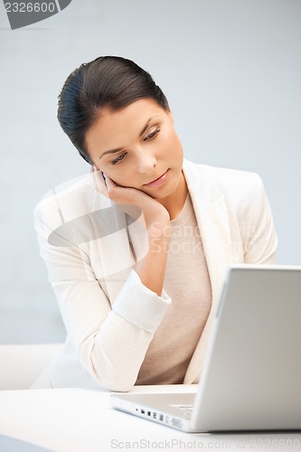 Image of pensive woman with laptop computer