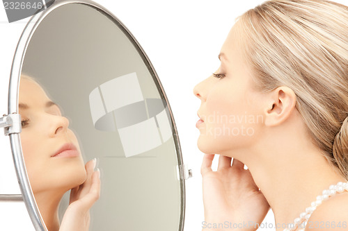 Image of beautiful woman with pearl beads and mirror