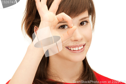 Image of teenage girl looking through hole from fingers