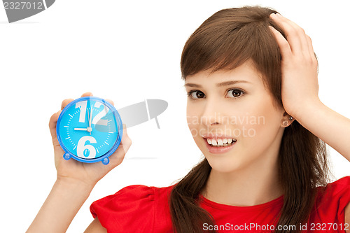 Image of teenage girl holding alarm clock