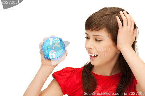 Image of teenage girl holding alarm clock