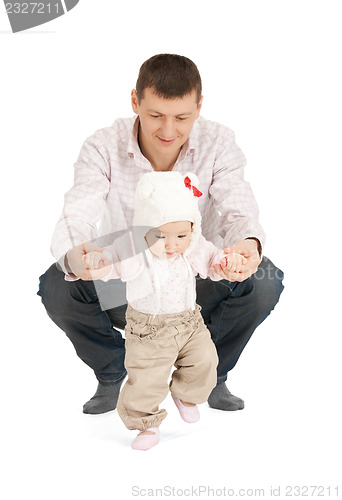 Image of baby making first steps with father help