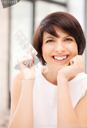 Image of young beautiful woman with pills