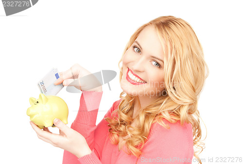 Image of lovely woman with piggy bank and money