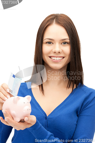 Image of lovely woman with piggy bank and money