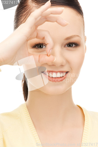 Image of lovely woman looking through hole from fingers