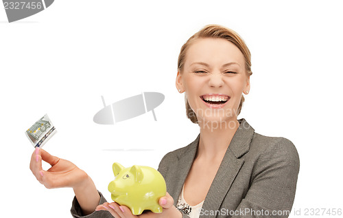 Image of lovely woman with piggy bank and money