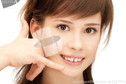Image of teenage girl making a call me gesture