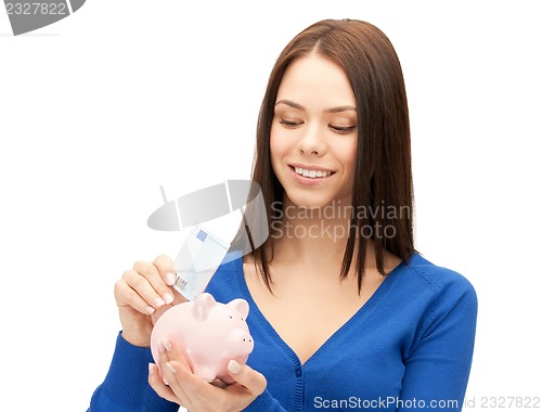 Image of lovely woman with piggy bank and money