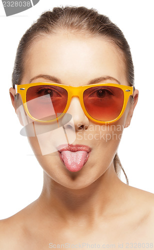 Image of teenage girl in shades sticking out her tongue