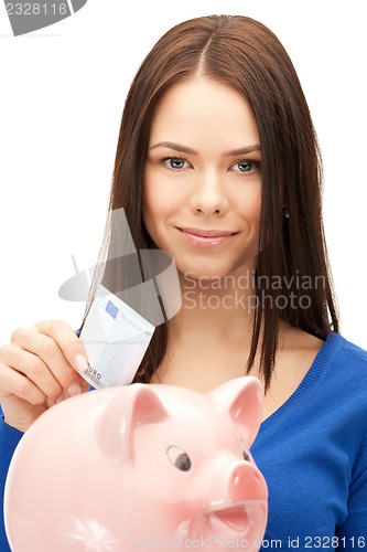 Image of lovely woman with piggy bank and money