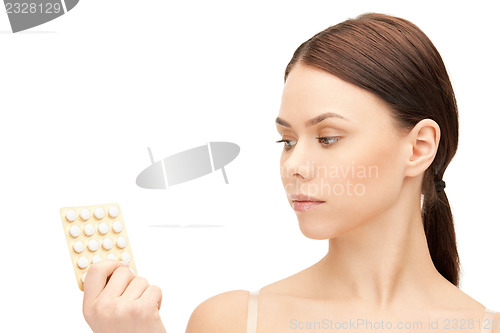 Image of young beautiful woman with pills