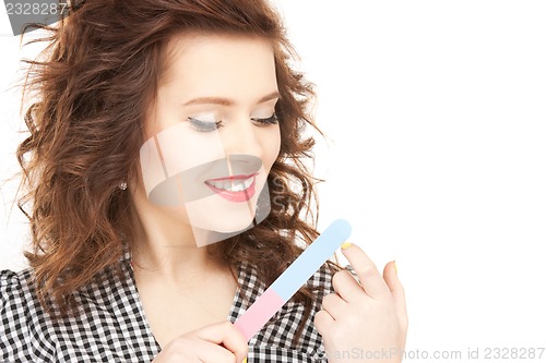 Image of beautiful woman polishing her nails