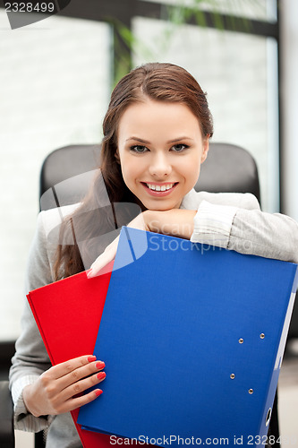 Image of young businesswoman with folders sitting in chair