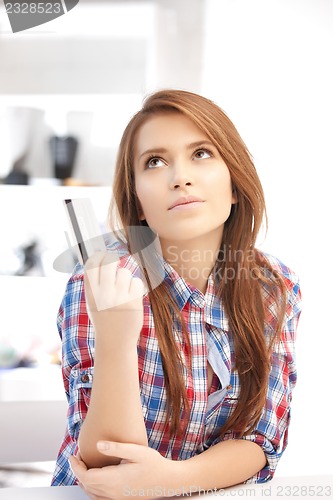 Image of pensive woman with credit card