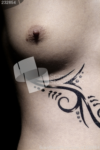 Image of female breast and tattoo