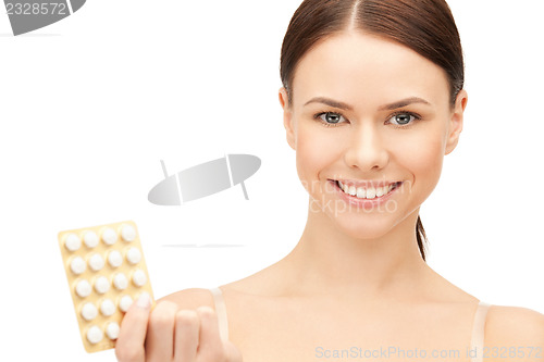 Image of young beautiful woman with pills