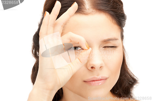 Image of lovely woman looking through hole from fingers