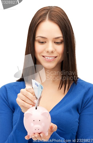 Image of lovely woman with piggy bank and money