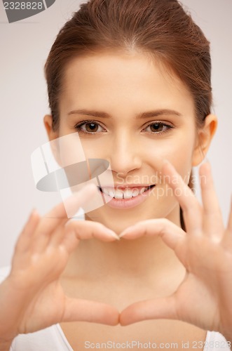 Image of happy woman making heart gesture