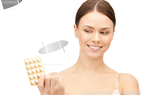 Image of young beautiful woman with pills