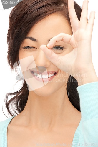 Image of lovely woman looking through hole from fingers