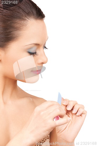 Image of beautiful woman polishing her nails