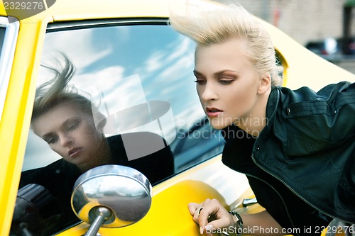 Image of fashionable woman with yellow car