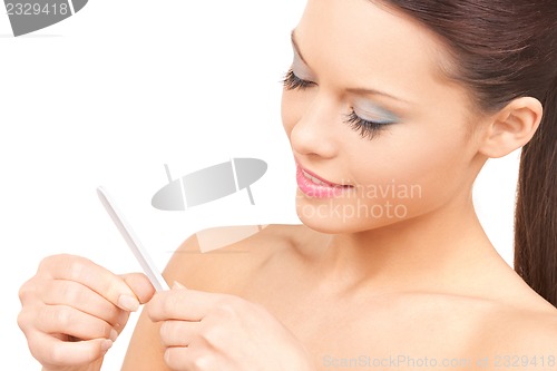 Image of beautiful woman polishing her nails