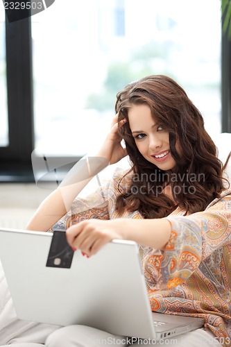 Image of happy woman with laptop computer and credit card