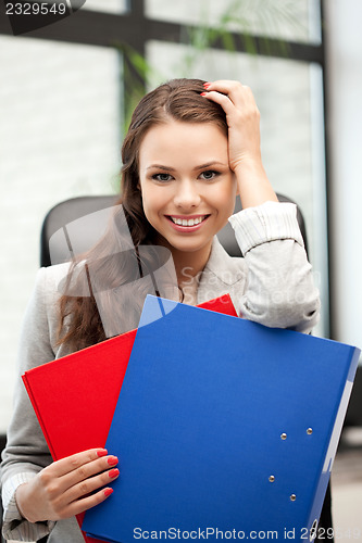 Image of young businesswoman with folders sitting in chair