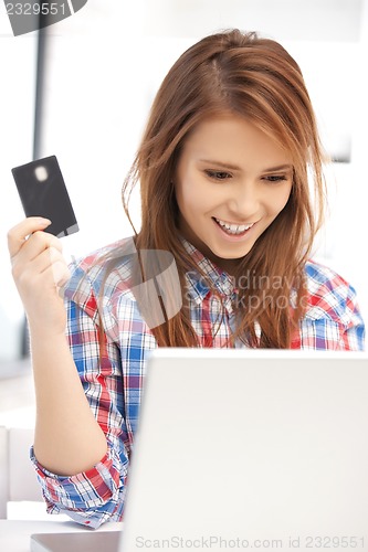 Image of happy woman with laptop computer and credit card