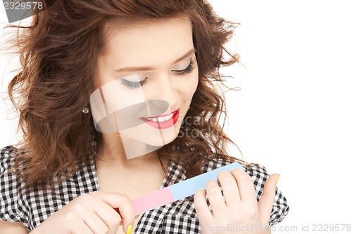 Image of beautiful woman polishing her nails