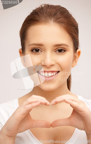 Image of happy woman making heart gesture