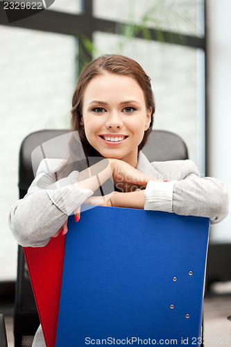 Image of young businesswoman with folders sitting in chair