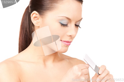 Image of beautiful woman polishing her nails