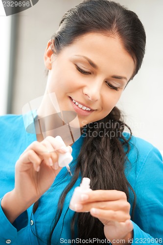 Image of beautiful woman polishing her nails